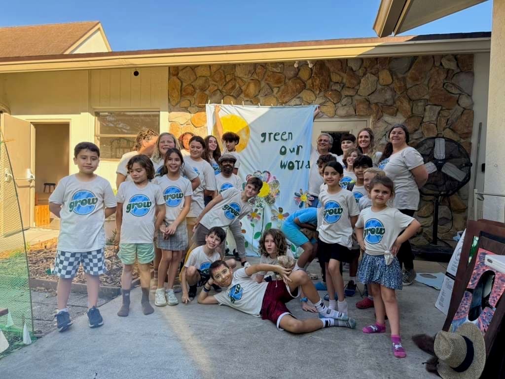 GROW community in matching shirts in front of the Green Our World banner